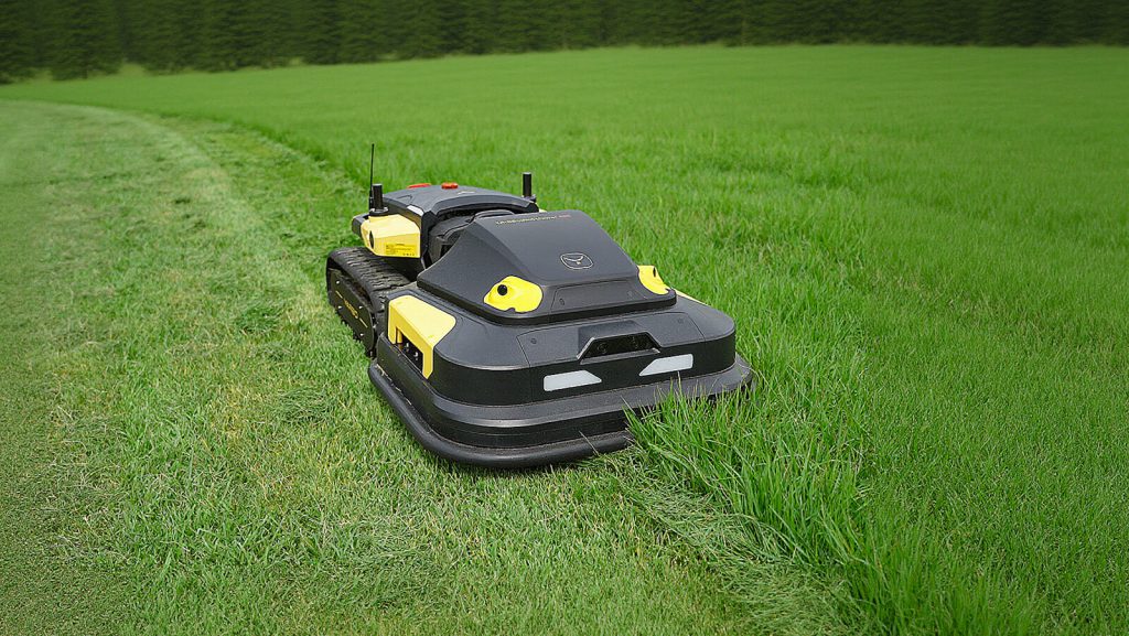 Tracked mower cutting grass in an open field